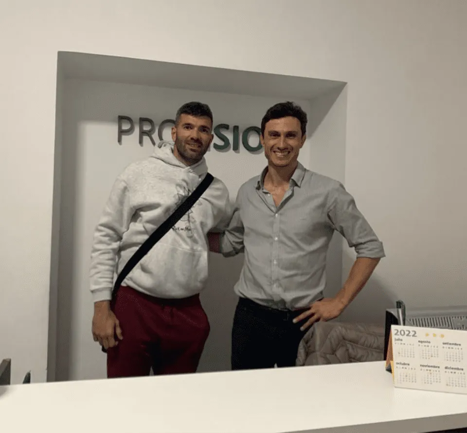 Dos profesionales posando junto a la recepción de Profisio
