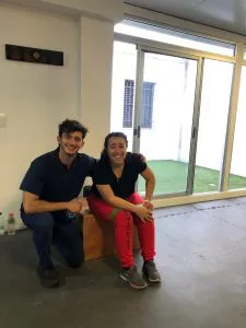 Dos personas sentadas sonriendo en una sala de la clínica